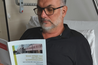 Patiënt leest brochure Week van de Pijn 